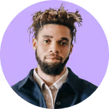 Professional headshot of a male employee with a beard wearing a dark blue overshirt.