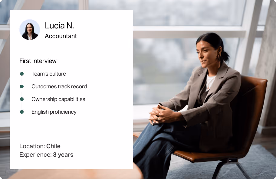 Woman in business attire sitting on chair looking thoughtful by large window during interview.