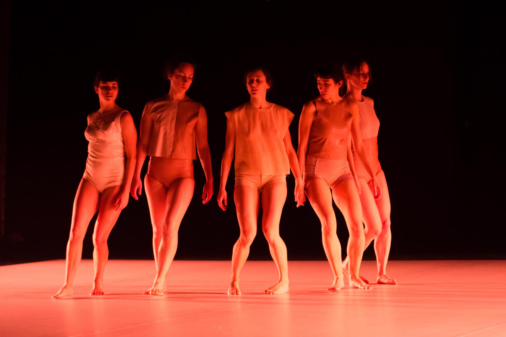 Grupo de bailarinas iluminadas con luz roja representando un momento de la coreografía La piel vacía de Paloma Muñoz en el SAT! Teatre de Barcelona