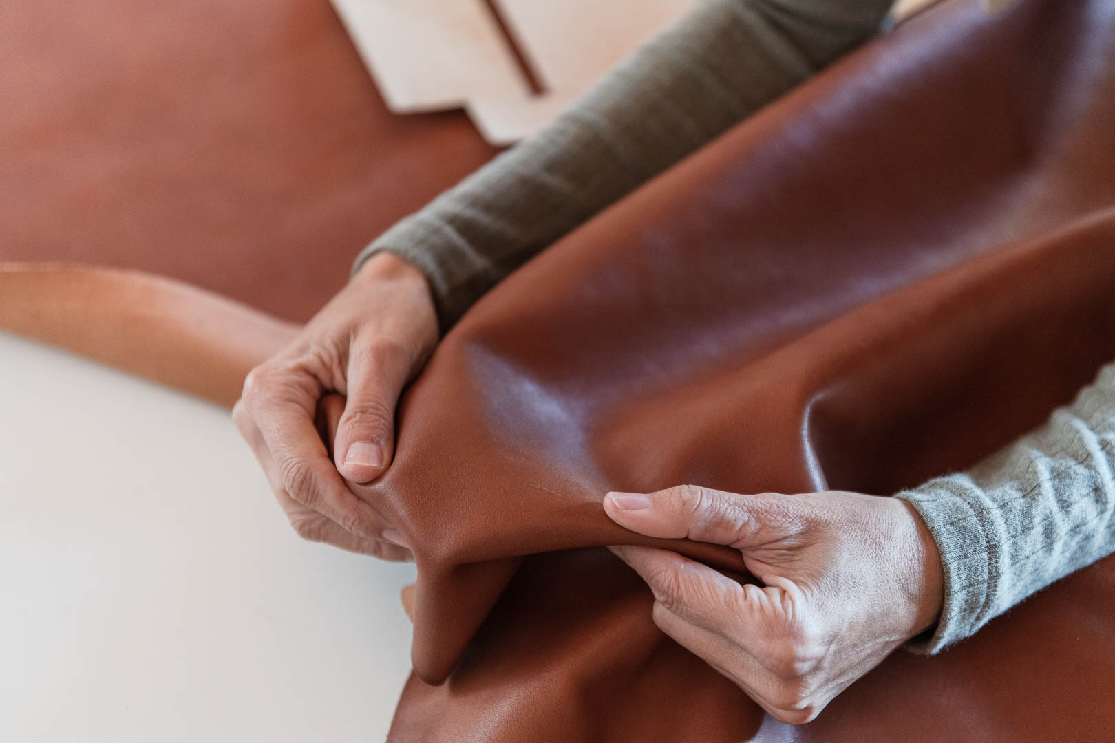 Detalle de las manos de una mujer artesana trabajando el cuero