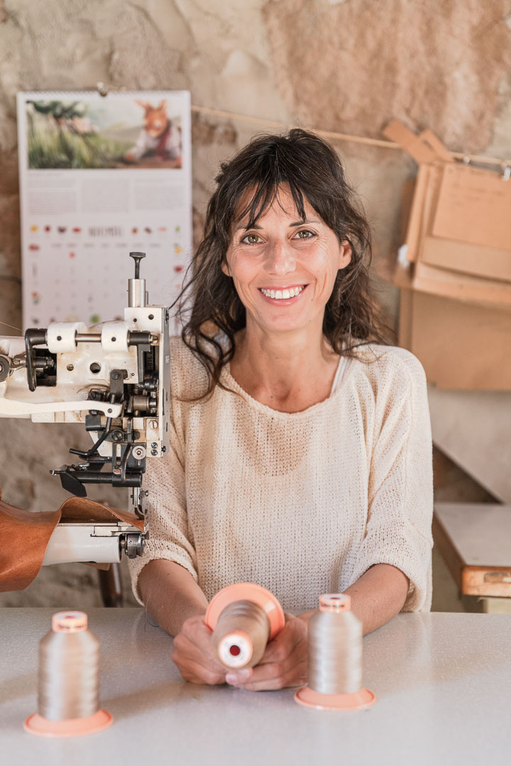 Retrato de una mujer en su taller con unas bobinas de hilo