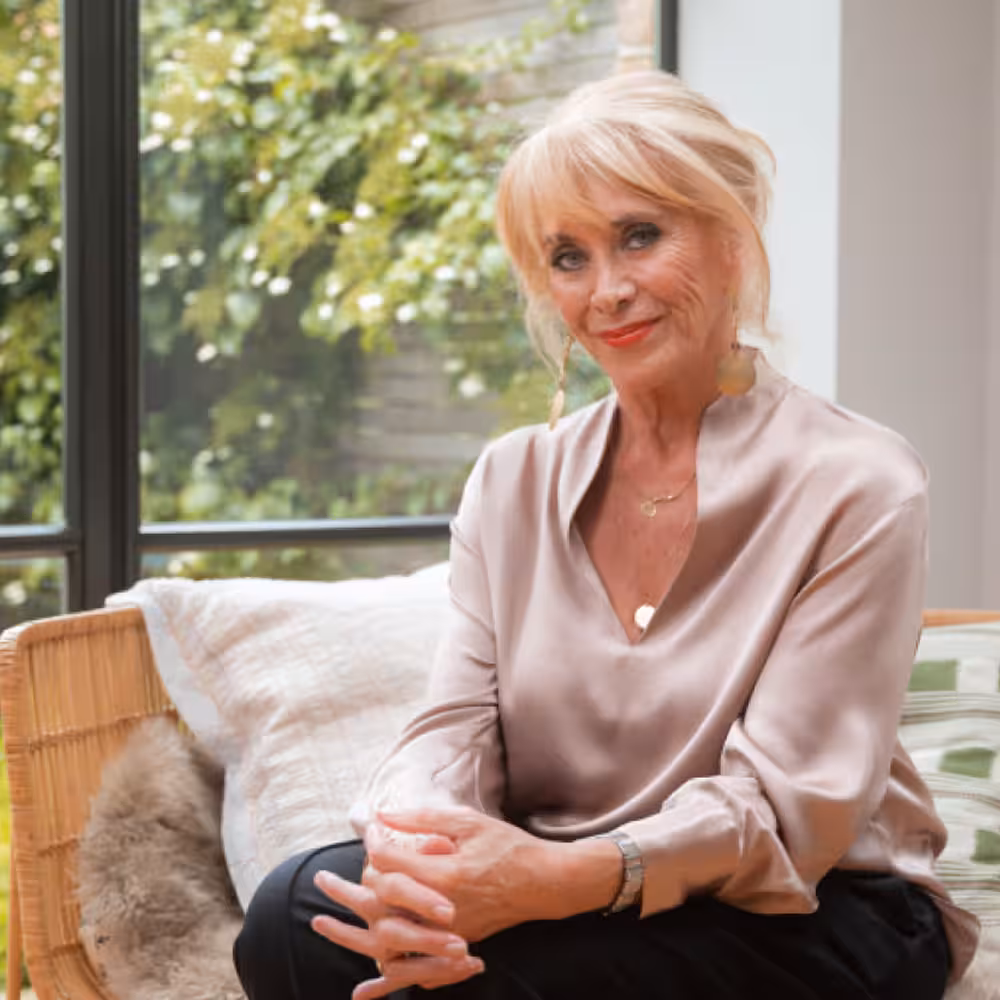 Confident woman in white shirt looking up with a clear blue sky background and a pink badge stating '25-day Money-back Guarantee'.