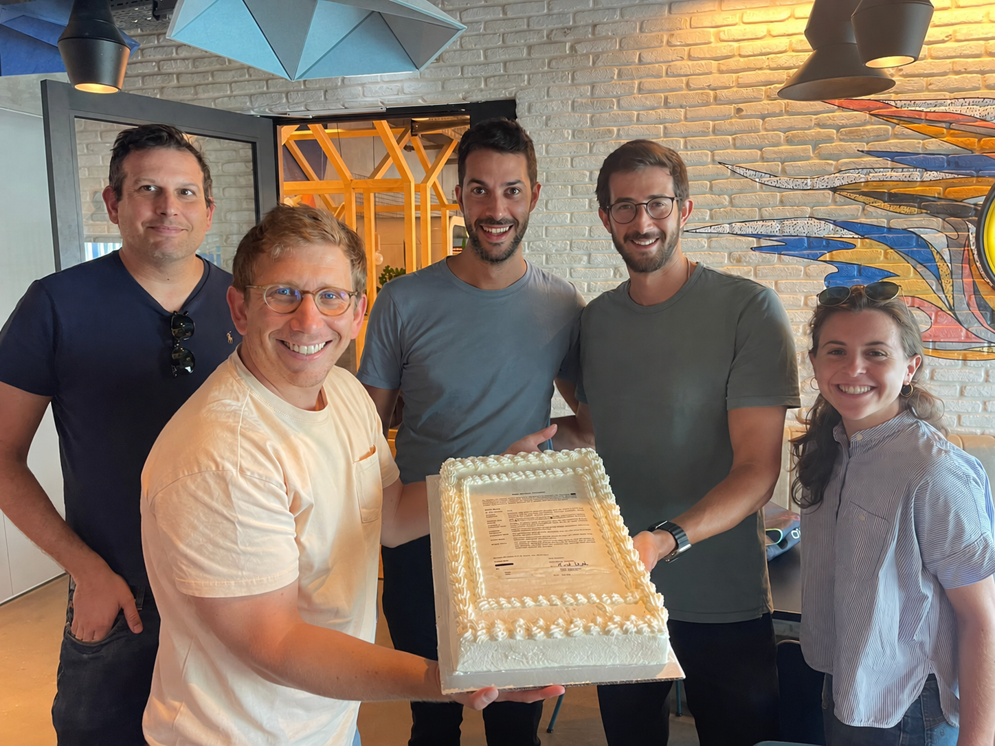 The team celebrating together with a cake