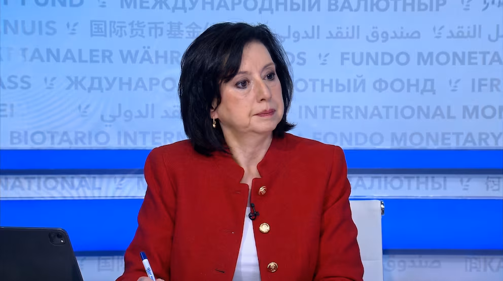 Julie Kozack, vocera del FMI, sentada frente a un fondo azul con el nombre del organismo en varios idiomas