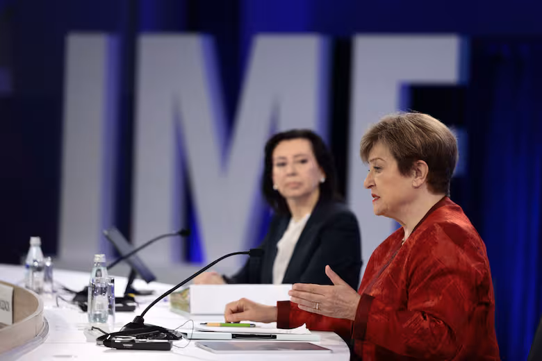Kristalina Georgieva habla ante un micrófono y, detrás, Julie Kozack, en un evento del FMI en Washington