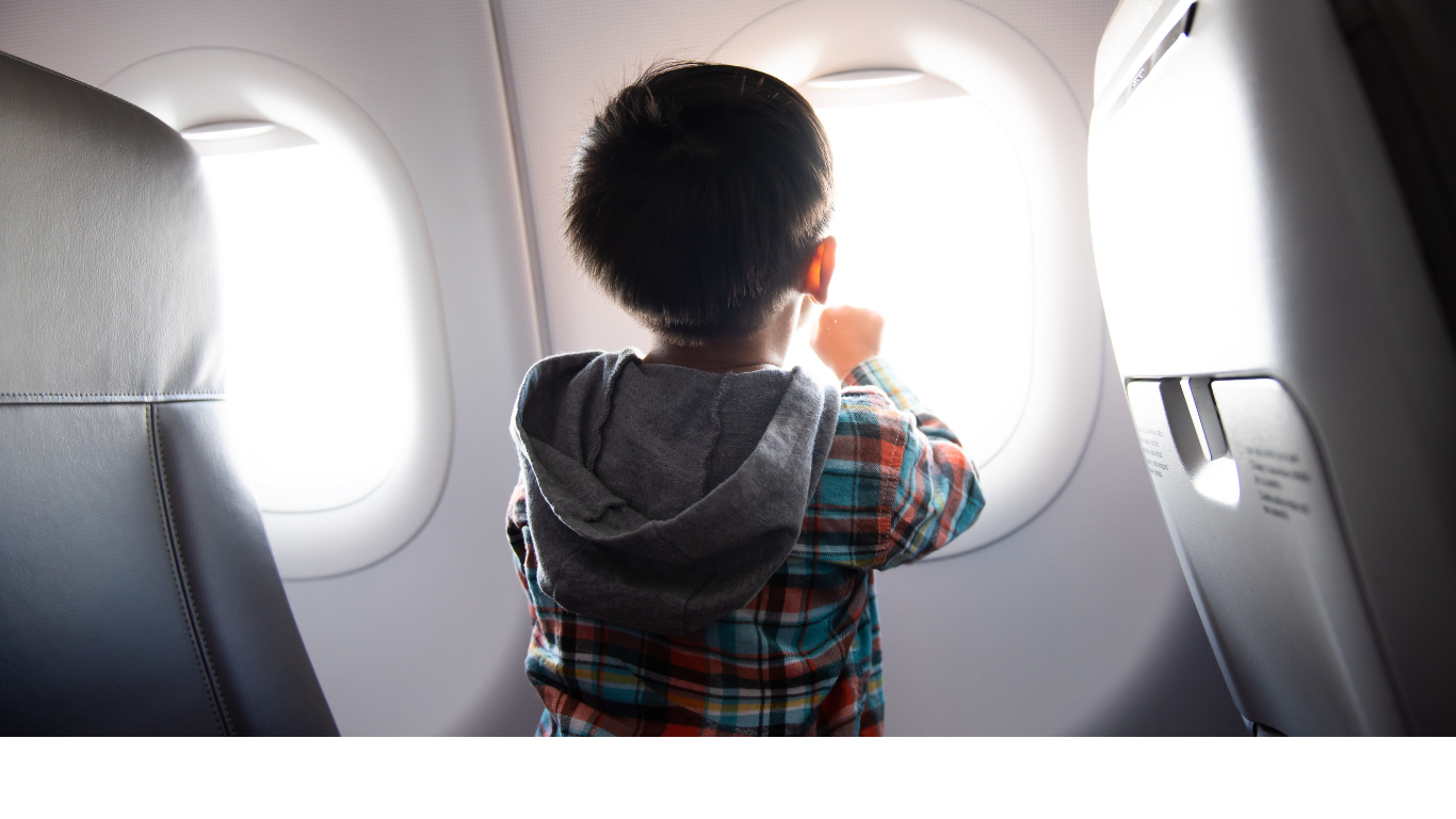 Child travelling on an aeroplane looking out the window