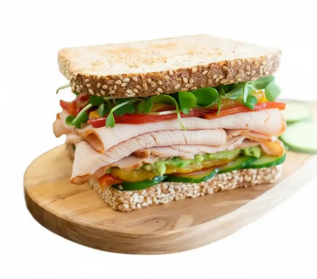 A turkey club sandwich on a wooden cutting board