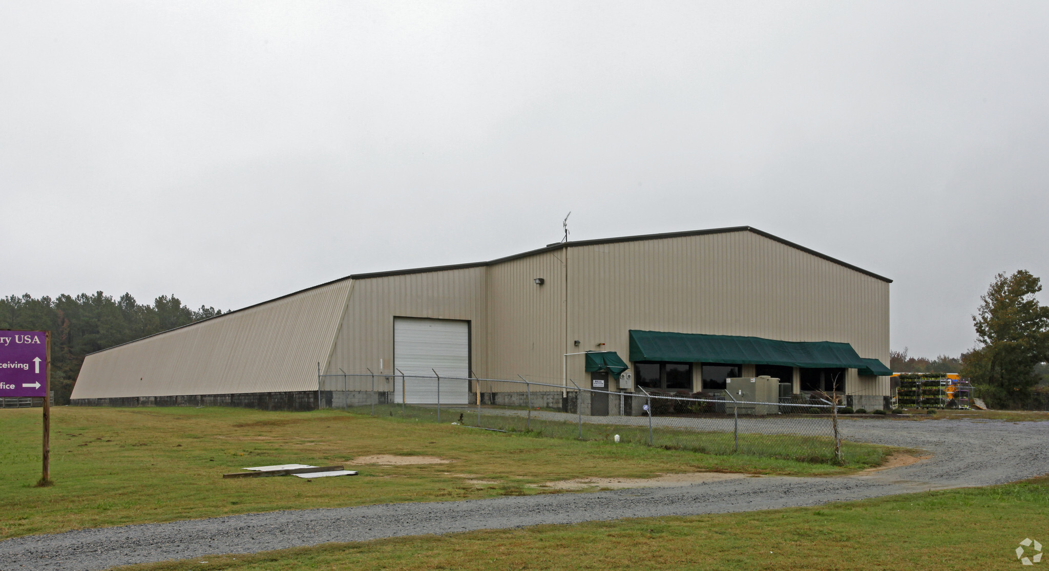 Exterior view of Orange Warehouse Corporation's headquarters and warehouse, showcasing a large industrial building surrounded by greenery, featured in Fulfill.com's article about the 3PL company's locations.