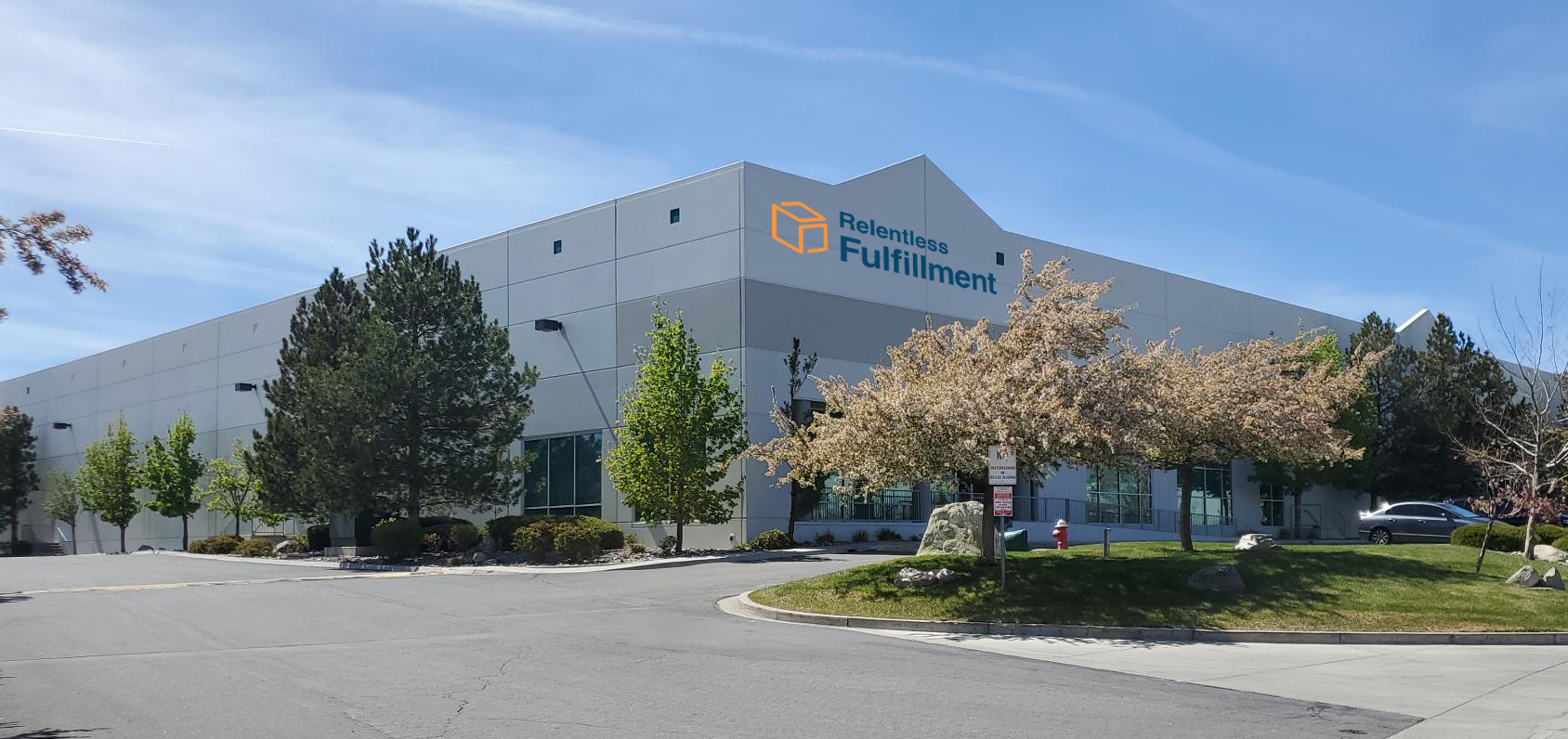 Exterior view of Relentless Fulfillment's warehouse and headquarters, showcasing the building's modern architecture surrounded by trees, featured in a Fulfill.com article.