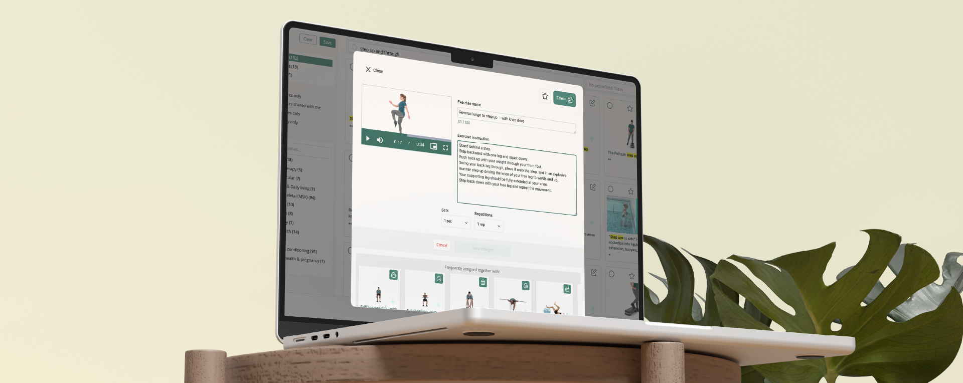 Auf einem Laptop, der auf einem Holzständer steht, ist die Benutzeroberfläche Physitrack zu sehen, wobei die Details zu den Übungen des Patienten auf dem Bildschirm geöffnet sind.