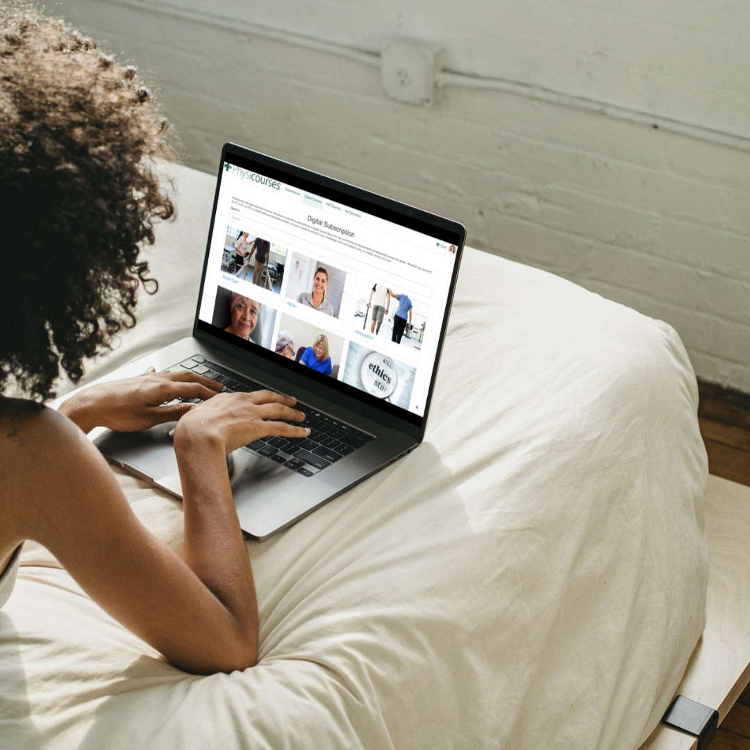 Woman lying on a bed using a laptop to browse an online learning website