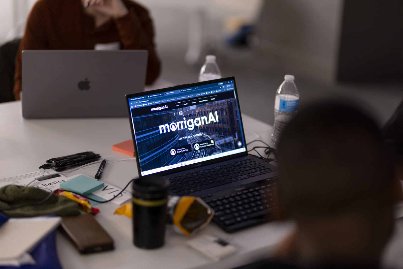 Laptop on a meeting table showing an AI product homepage during a working session