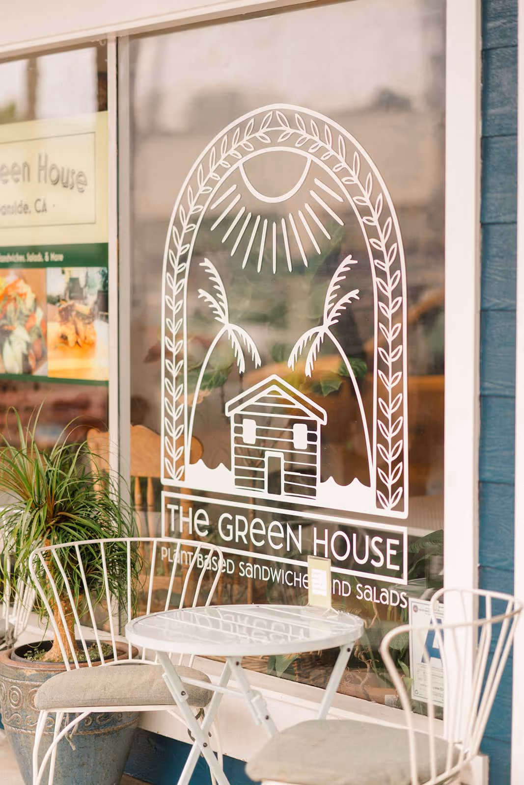 A white vinyl of a sandwich shop logo on a storefront window.