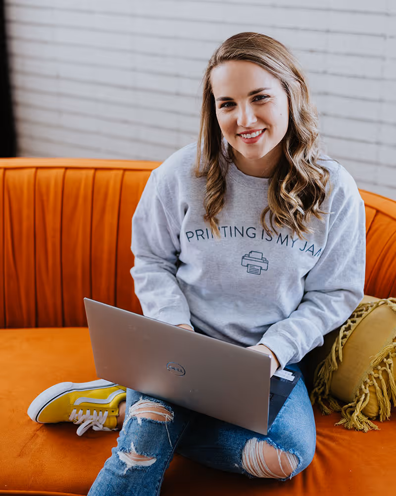 A wedding planner working on her marketing strategy at her laptop. Photo credit Bloom and Flourish Studio