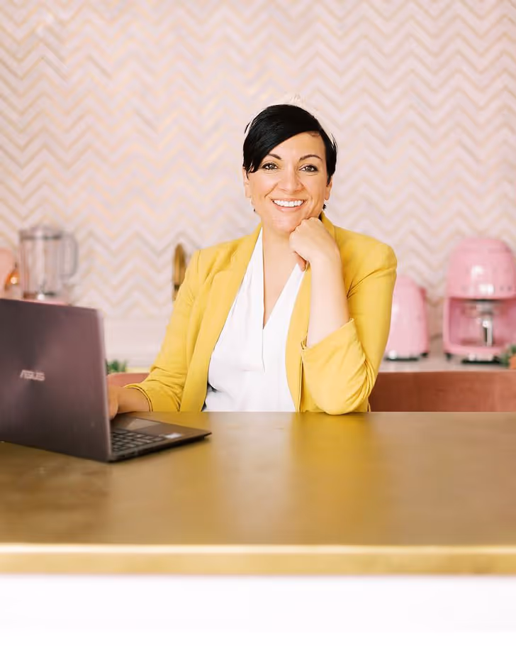 A male bike mechanic standing outside of his small business bike shop holding a bike.
