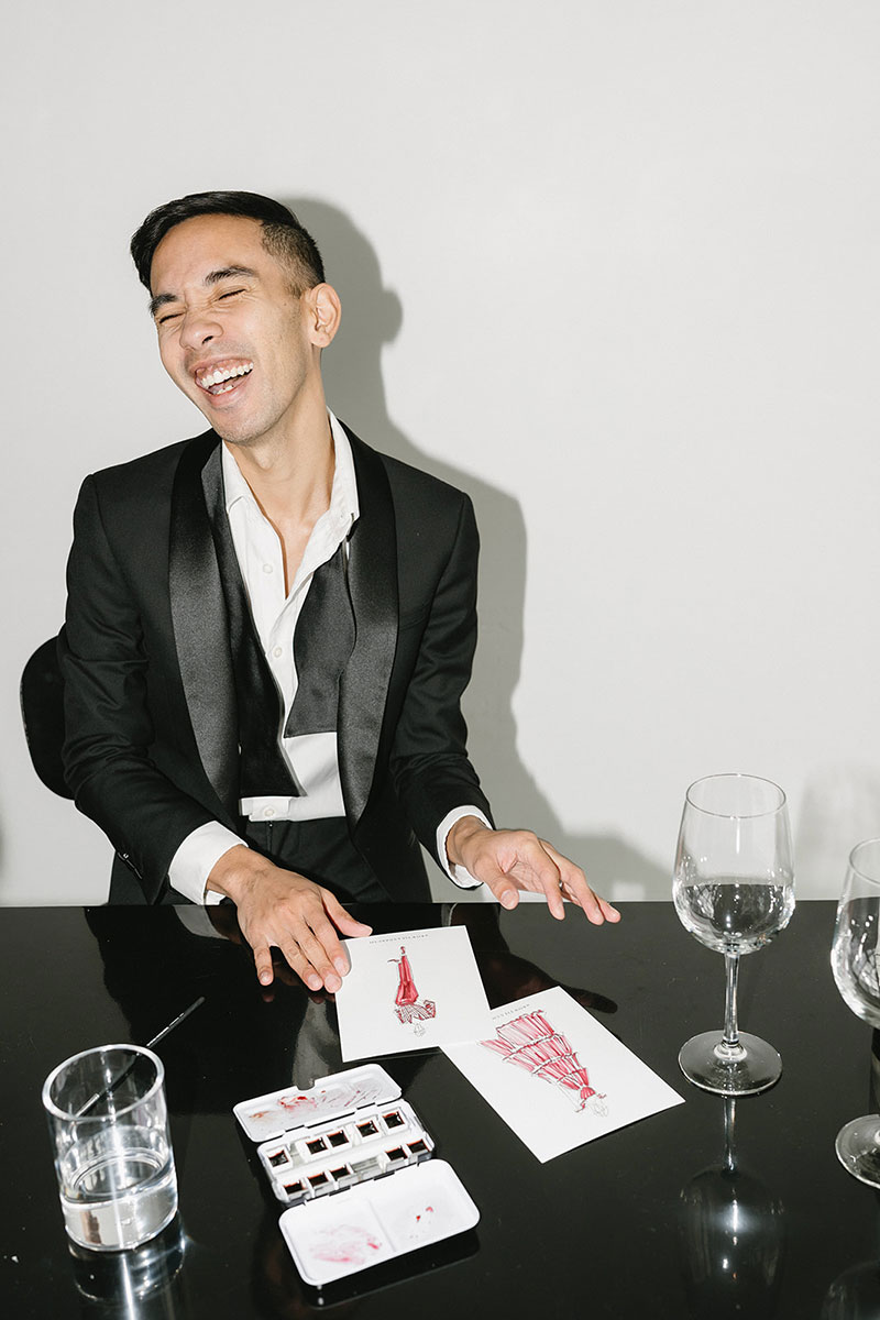 A male bike mechanic standing outside of his small business bike shop holding a bike.
