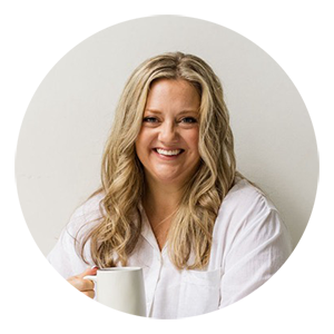 Headshot of a woman in a white blouse holding a coffee mug