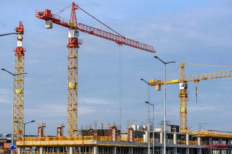 Active construction site with industrial cranes, symbolizing the development of renewable energy infrastructure and cleantech projects.