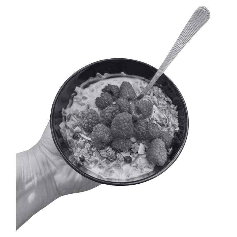 Hand holding a healthy breakfast bowl with raspberries for an influencer marketing case study.