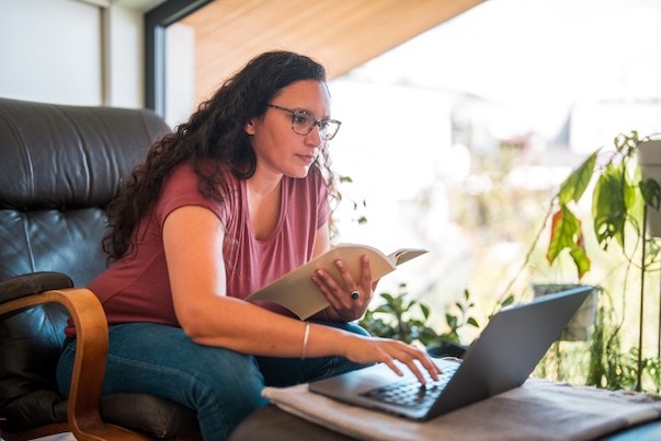 person sitting at table reading computer screen
