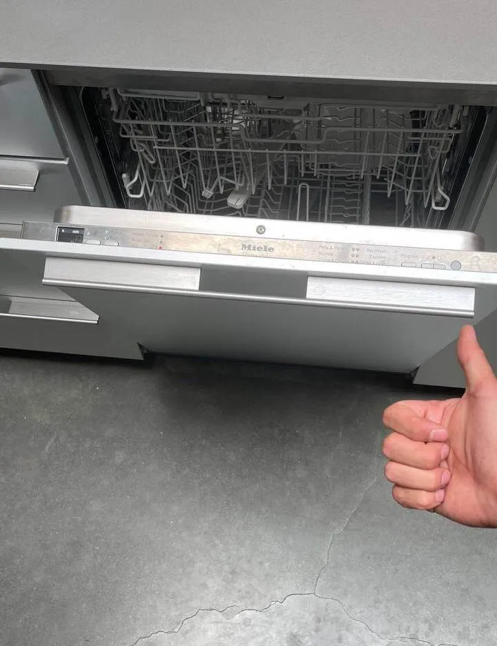 Open dishwasher with a thumbs-up gesture – Trusted dishwasher troubleshooting and repair.
