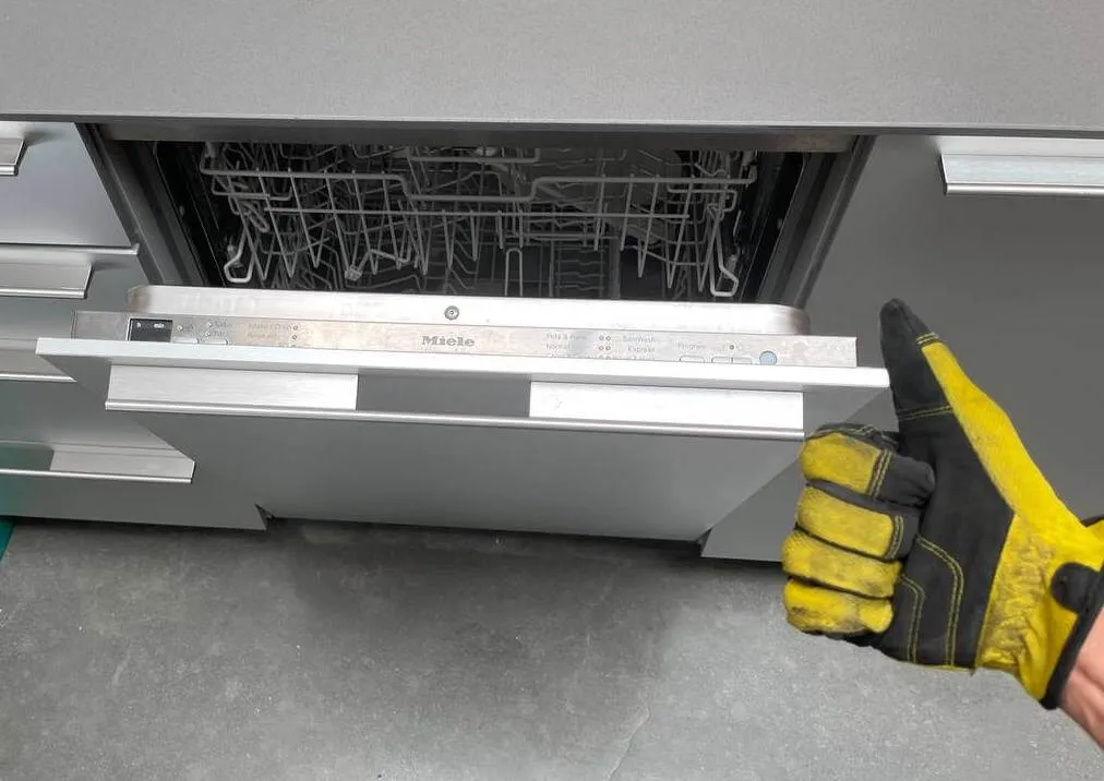 Open dishwasher showing clean dishes with a thumbs-up – Expert dishwasher maintenance and repair.