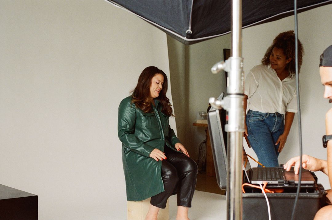 Film photo of a model in a green leather jacket being styled on set