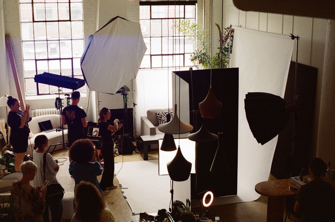 Film photo of a production crew working with large lights inside the loft