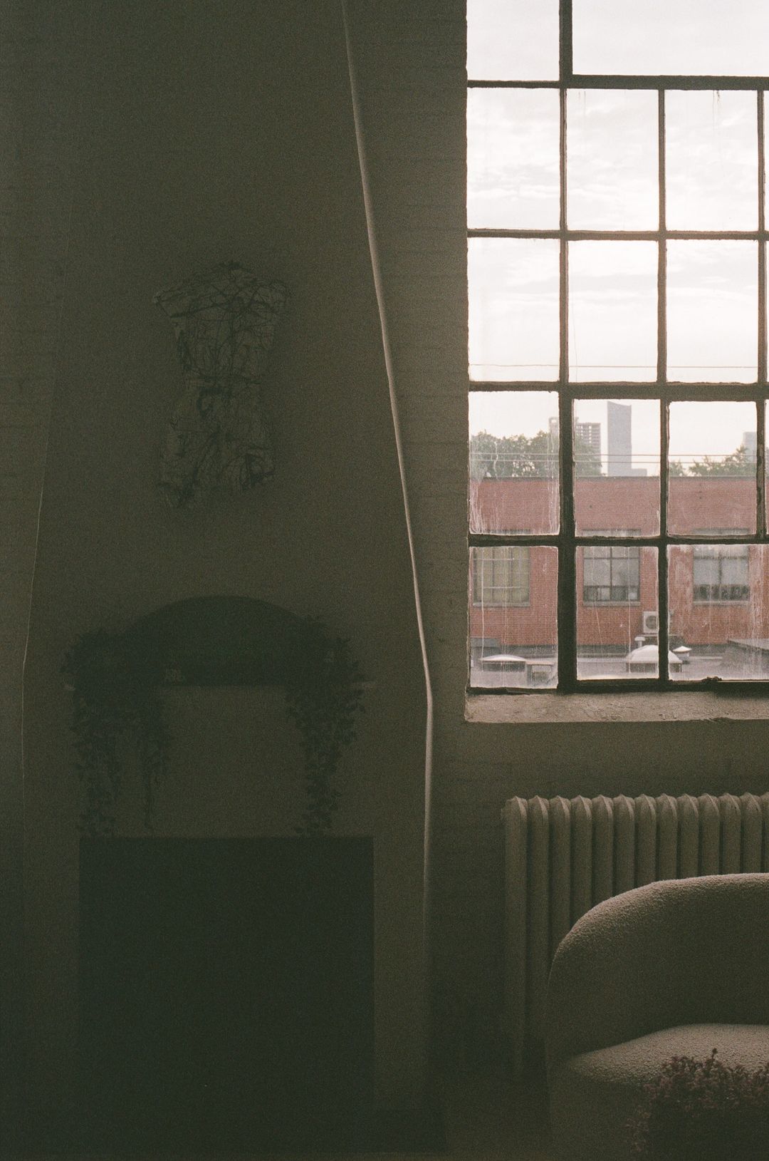 Moody view of the fireplace and factory window in low light