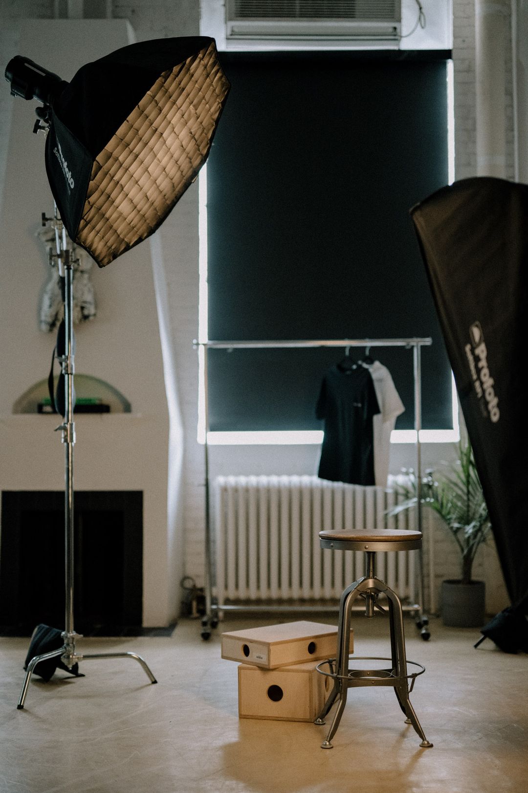 Softbox, stool and apple box set in front of blackout blinds