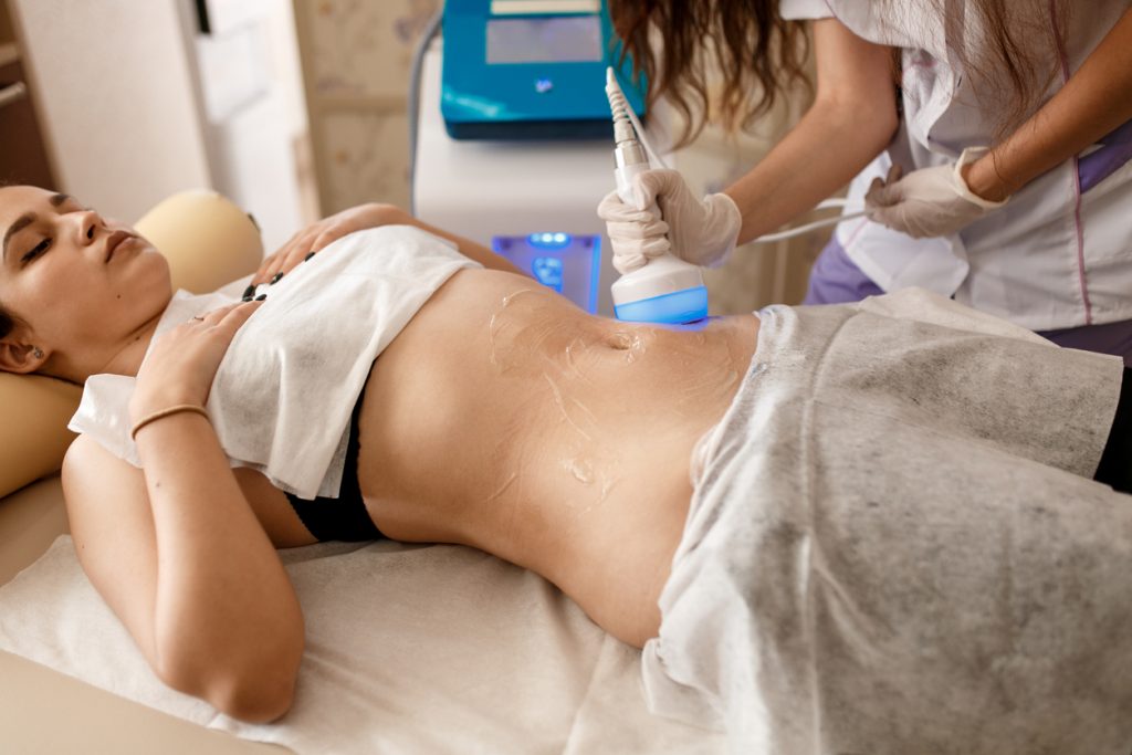 Hardware cosmetology. Body care. Spa treatment. Ultrasound cavitation body contouring treatment. Woman getting anti-cellulite and anti-fat therapy in beauty salon