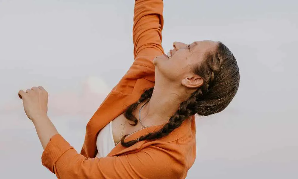 Meisje met vlechten reikend naar de lucht