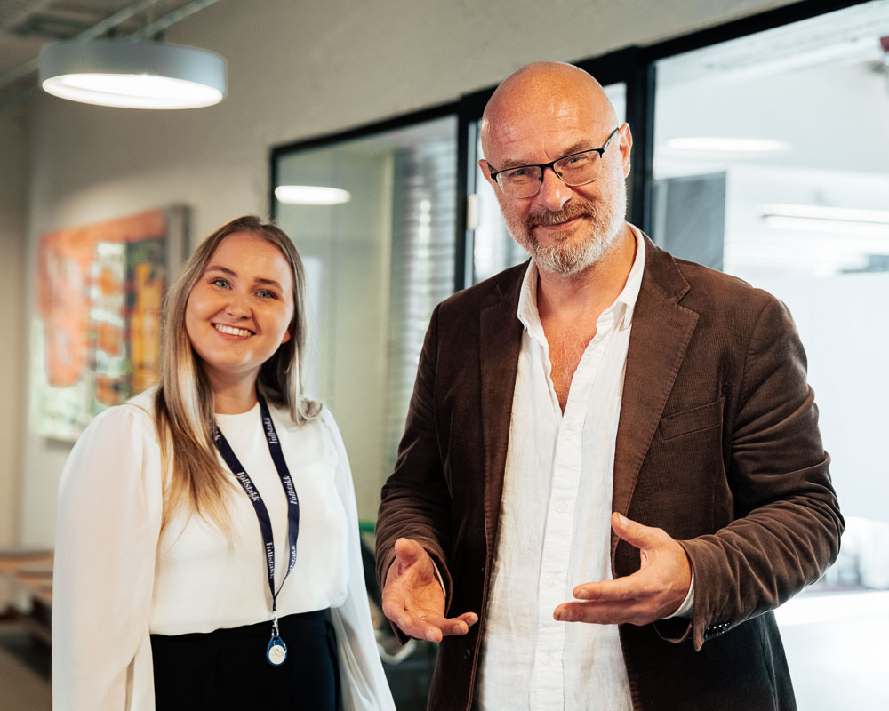 Smilende kvinne og mann som ser mot kamera