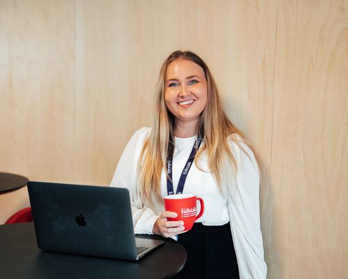 smilende kvinne med rød kaffekopp