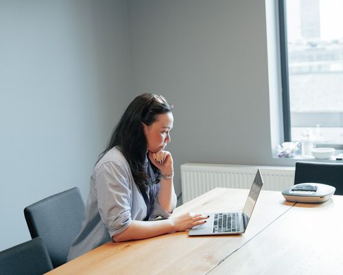 Helene sitter og ser ned i en pc-skjerm