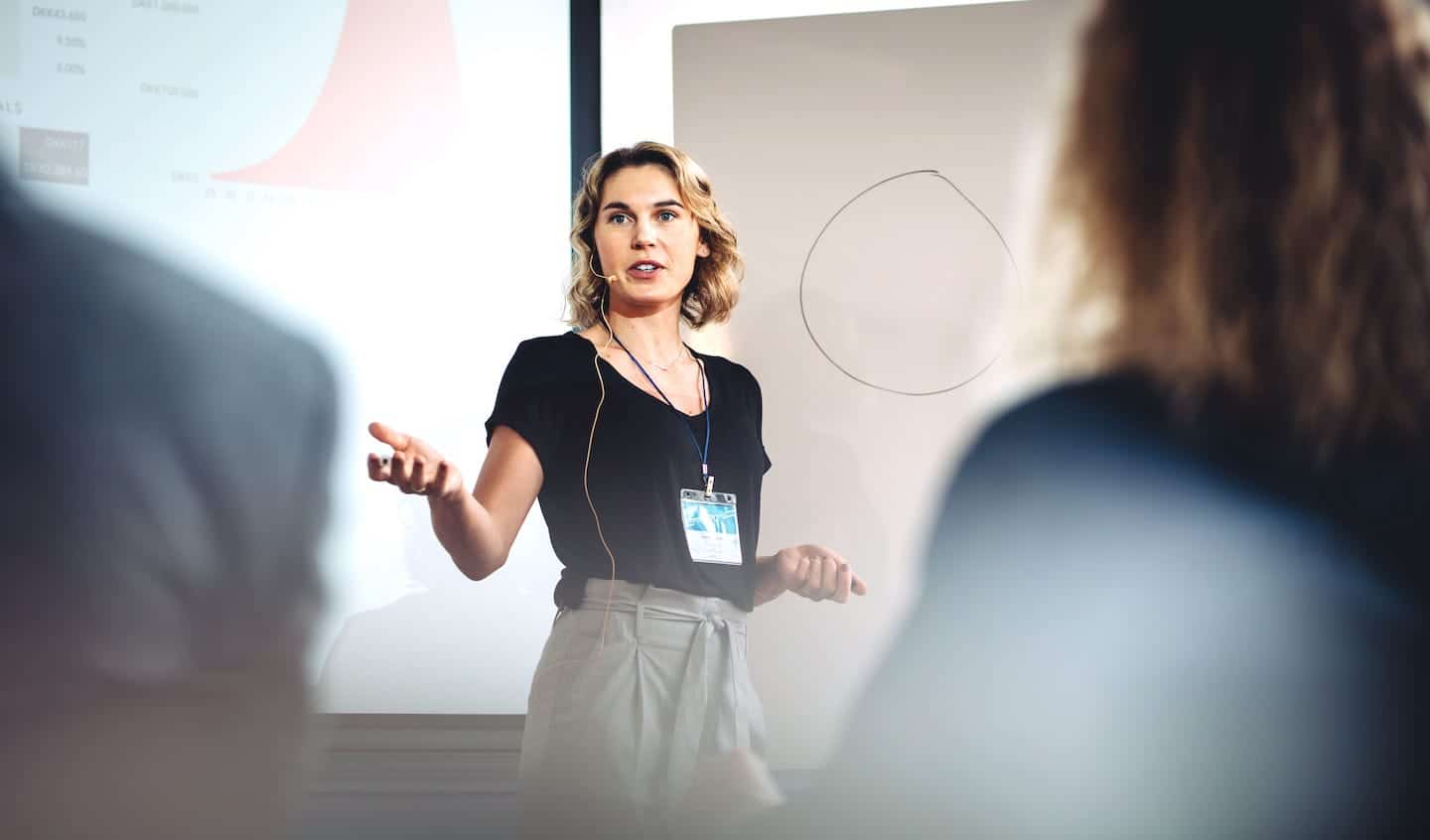 Photo of a woman speaking in front of a large audience