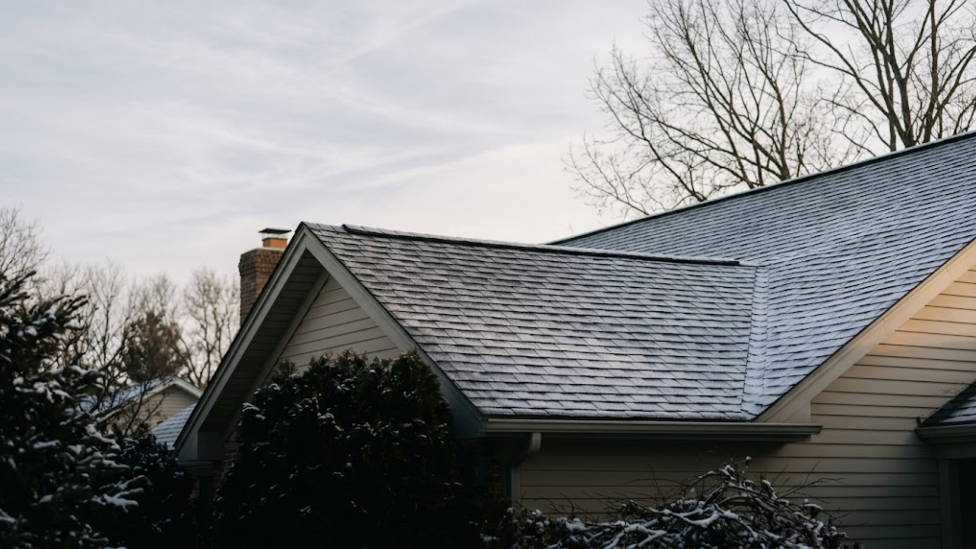 Asphalt shingle roof with light frost and first snow, ready for winter