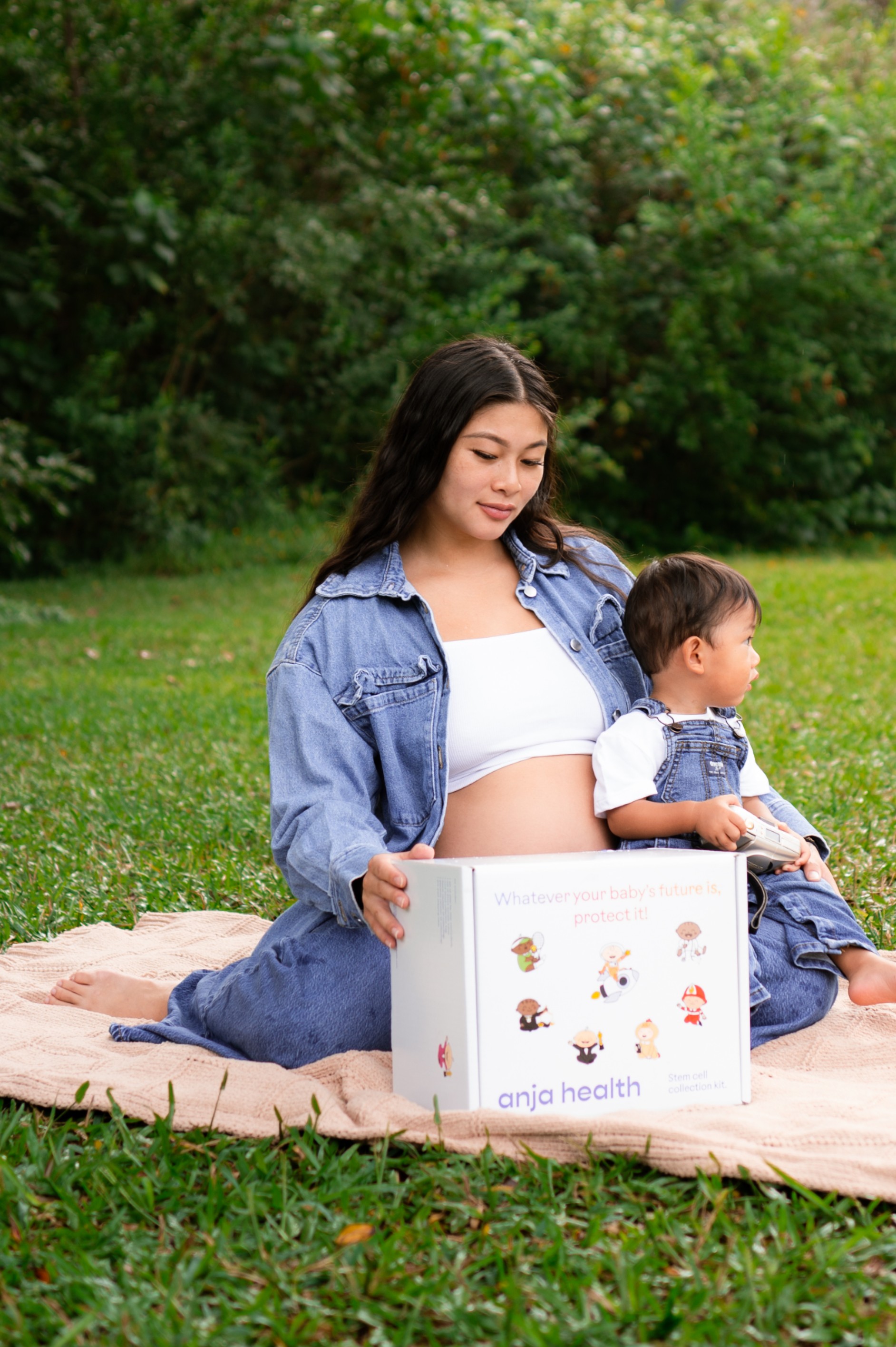 Three babies gathered around an Anja Health collection kit box
