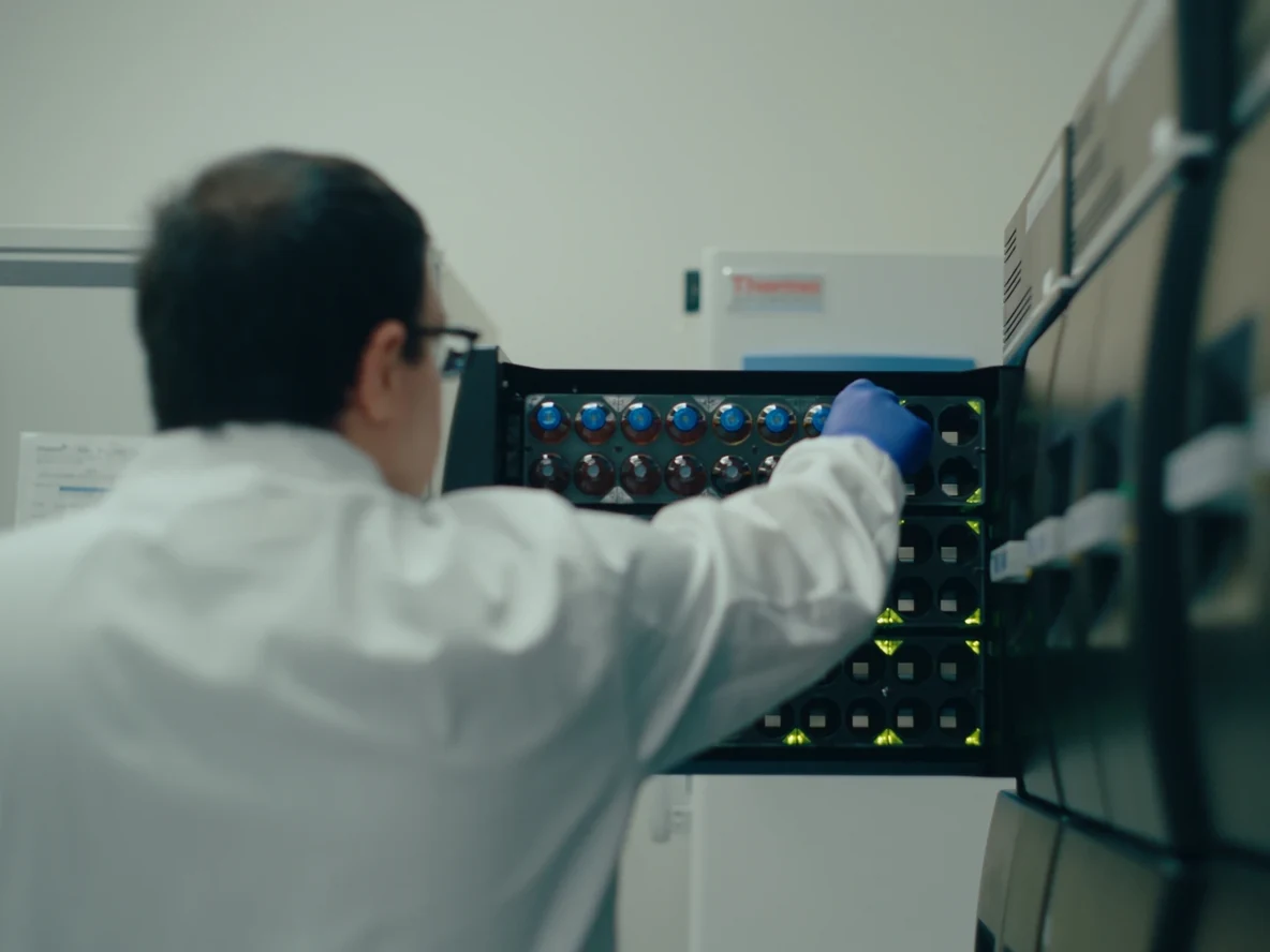 Lab technician placing samples into a storage rack at the lab