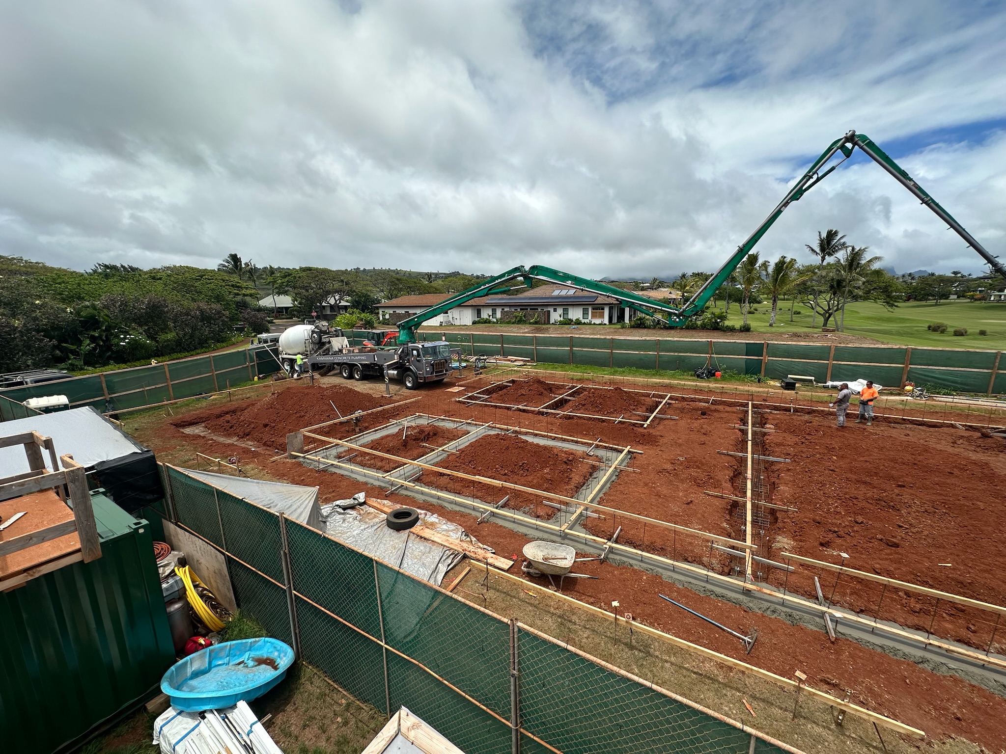 Concrete being pumped into formed footing trenches
