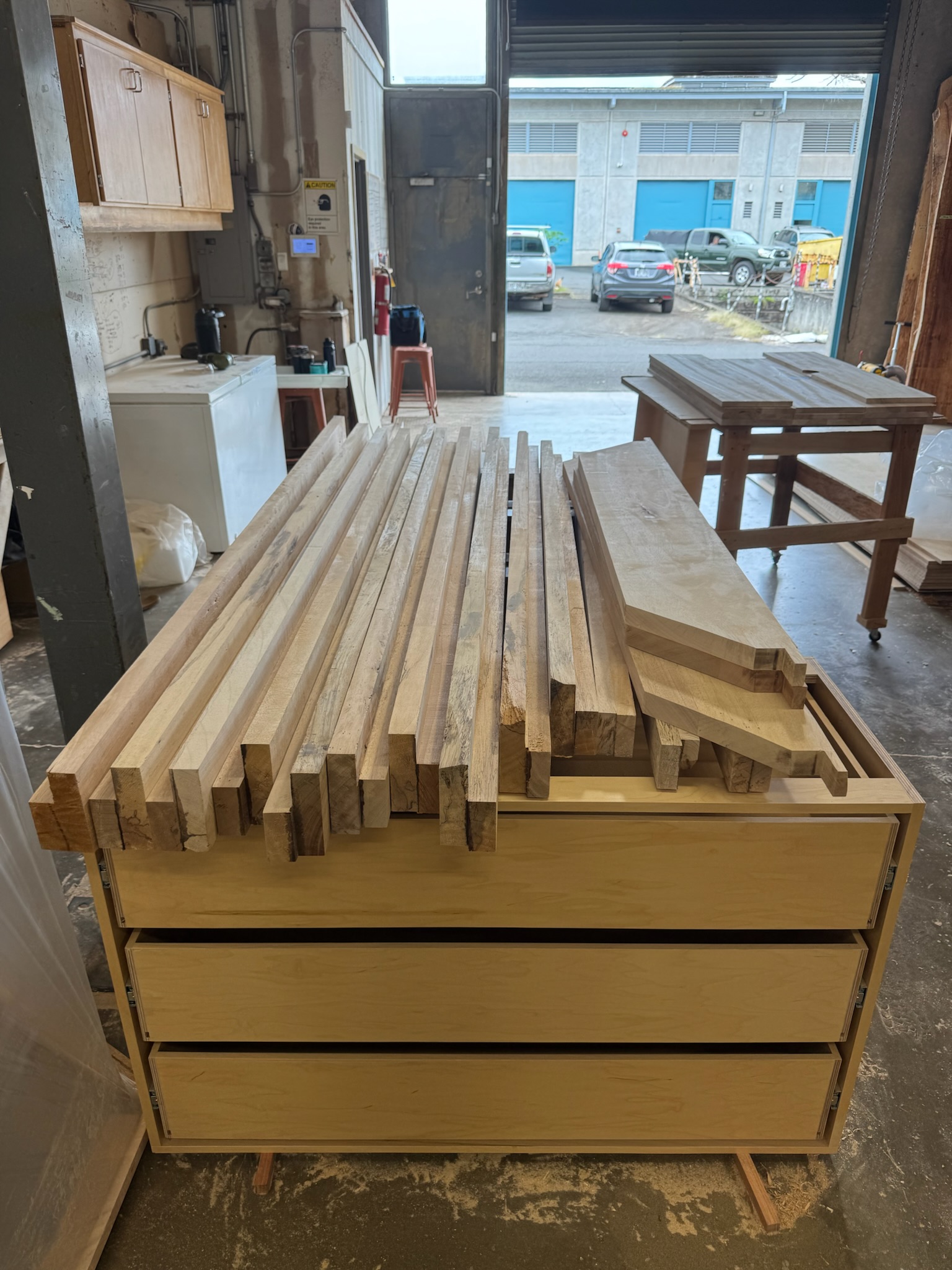 Raw albizia lumber staged in a shop