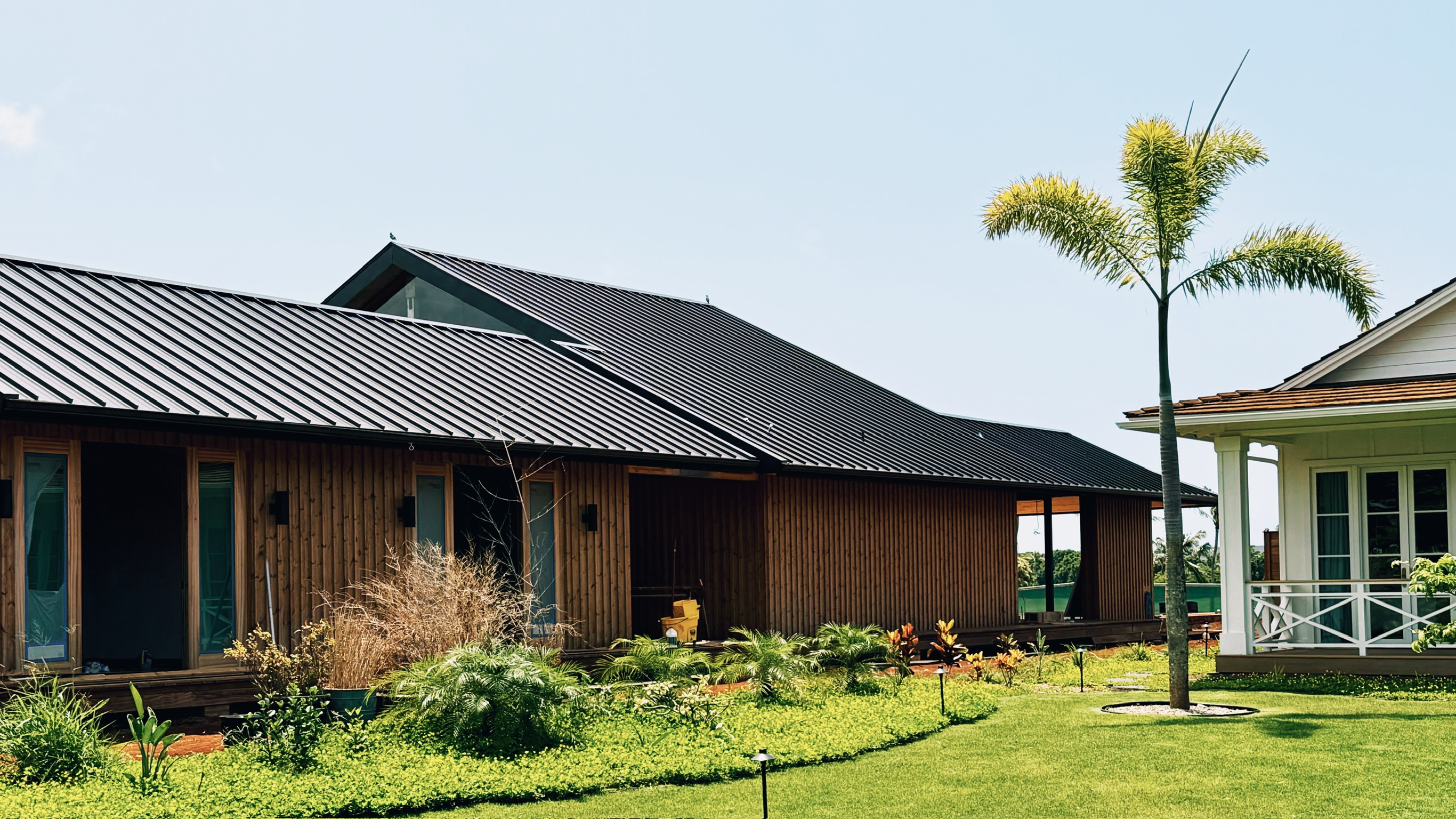Finished home exterior with dark roof and landscaping
