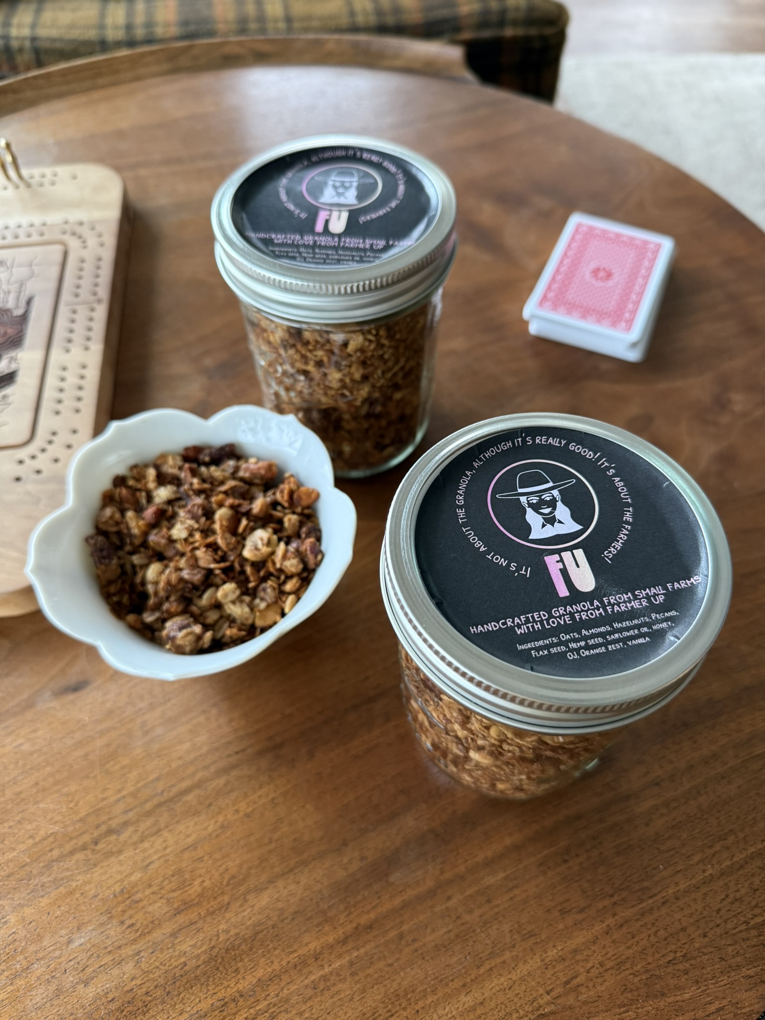 Jars and a bowl of Farmer Up granola on a wooden table