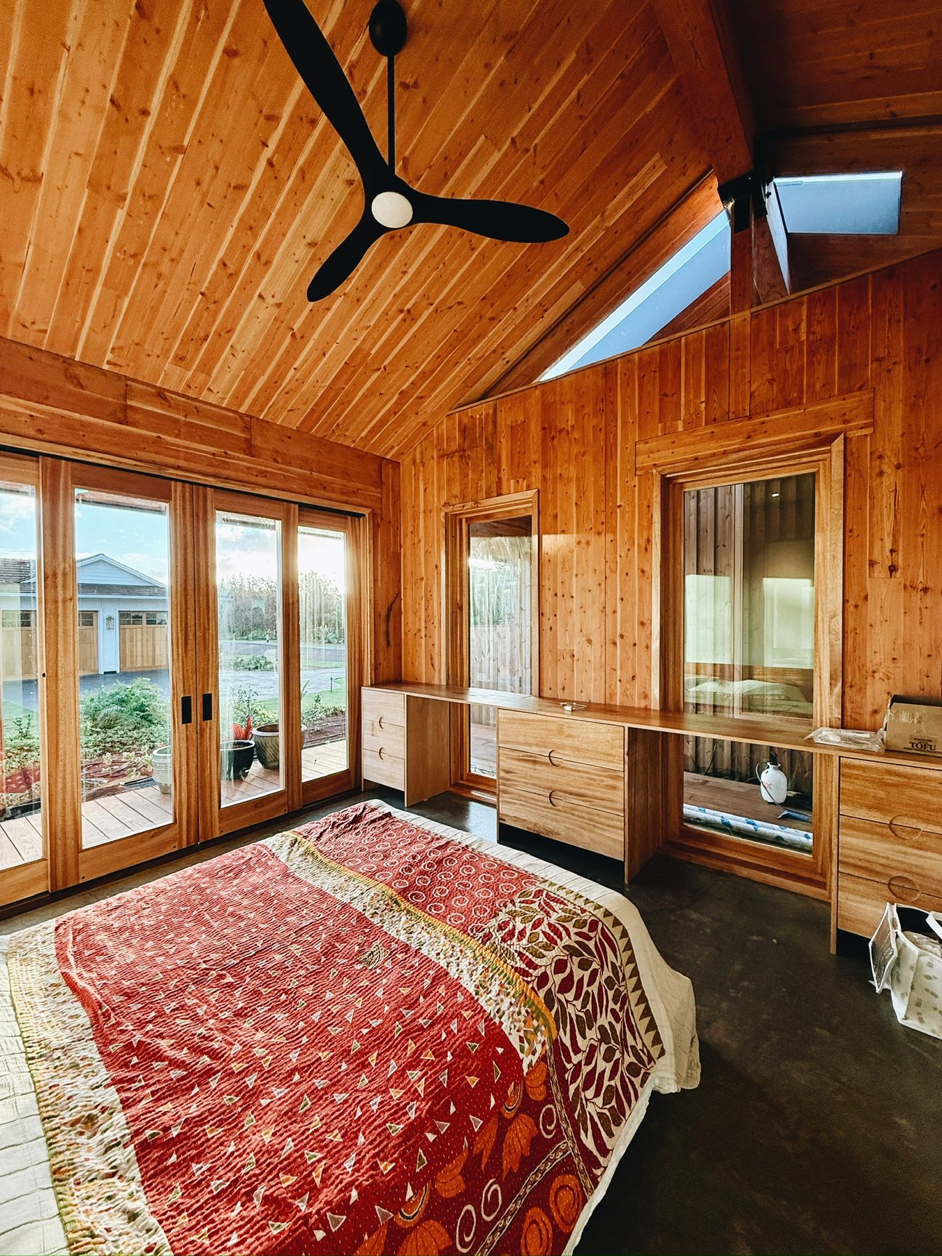 Finished bedroom with wood walls and built-in dressers