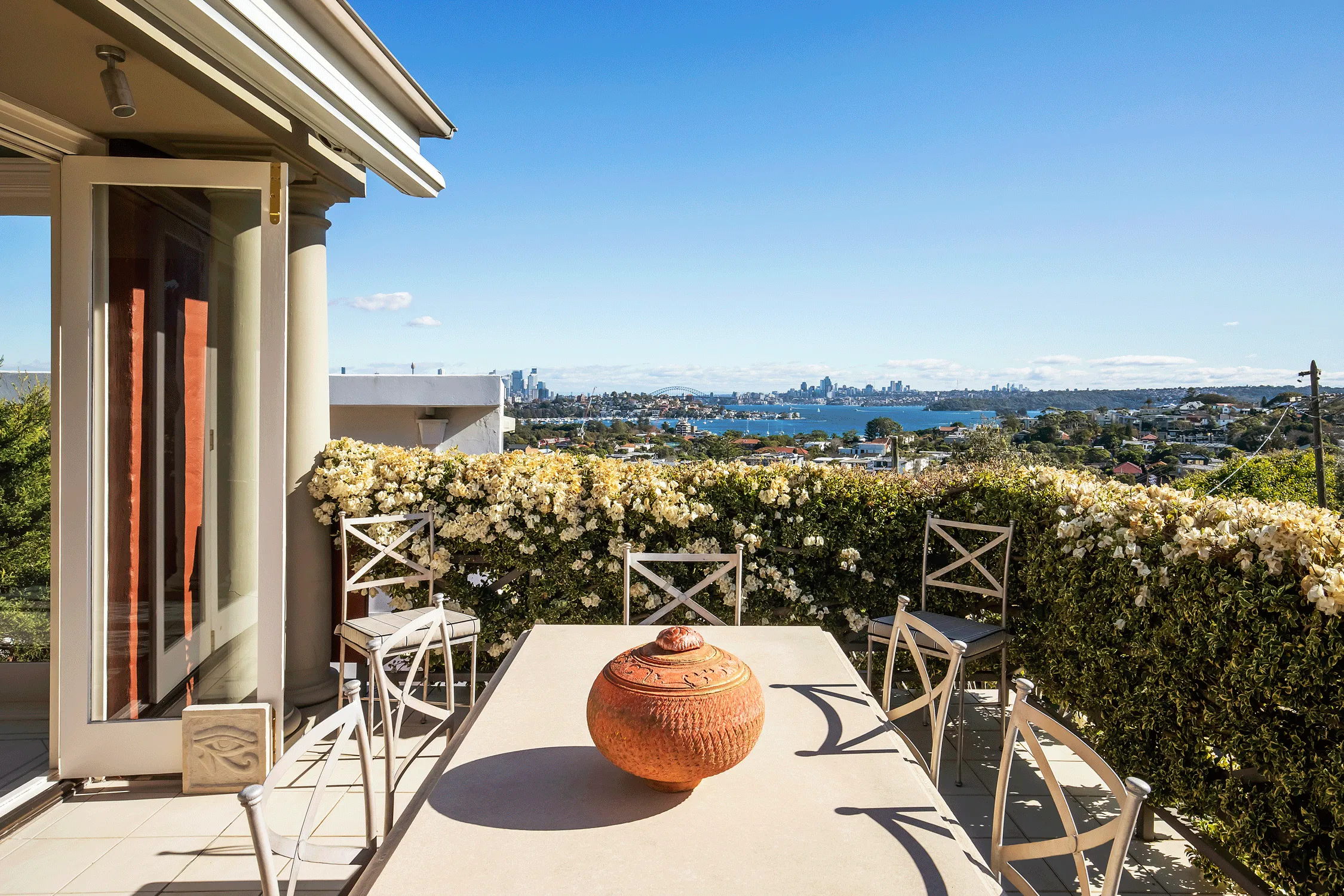 a balcony with an outdoor table and chairs at La Vie en Rose, short term rental in Sydney Harbour