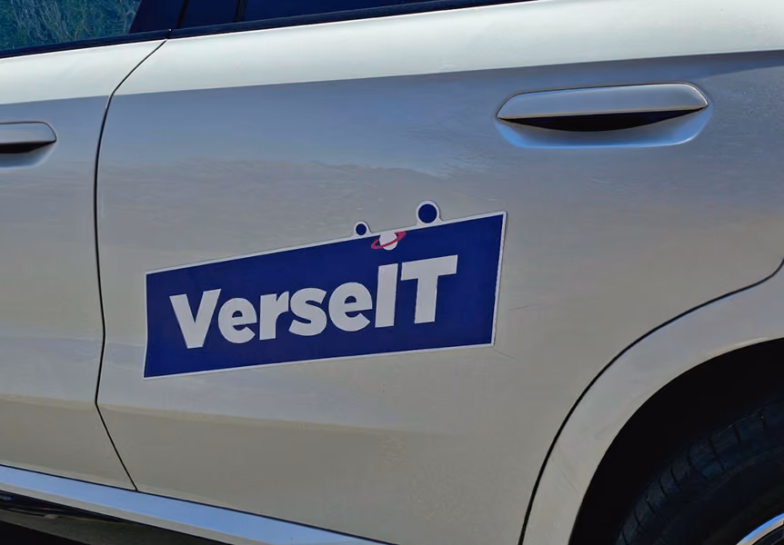 White car door with a blue rectangular decal reading 'VerseIT' in white letters.