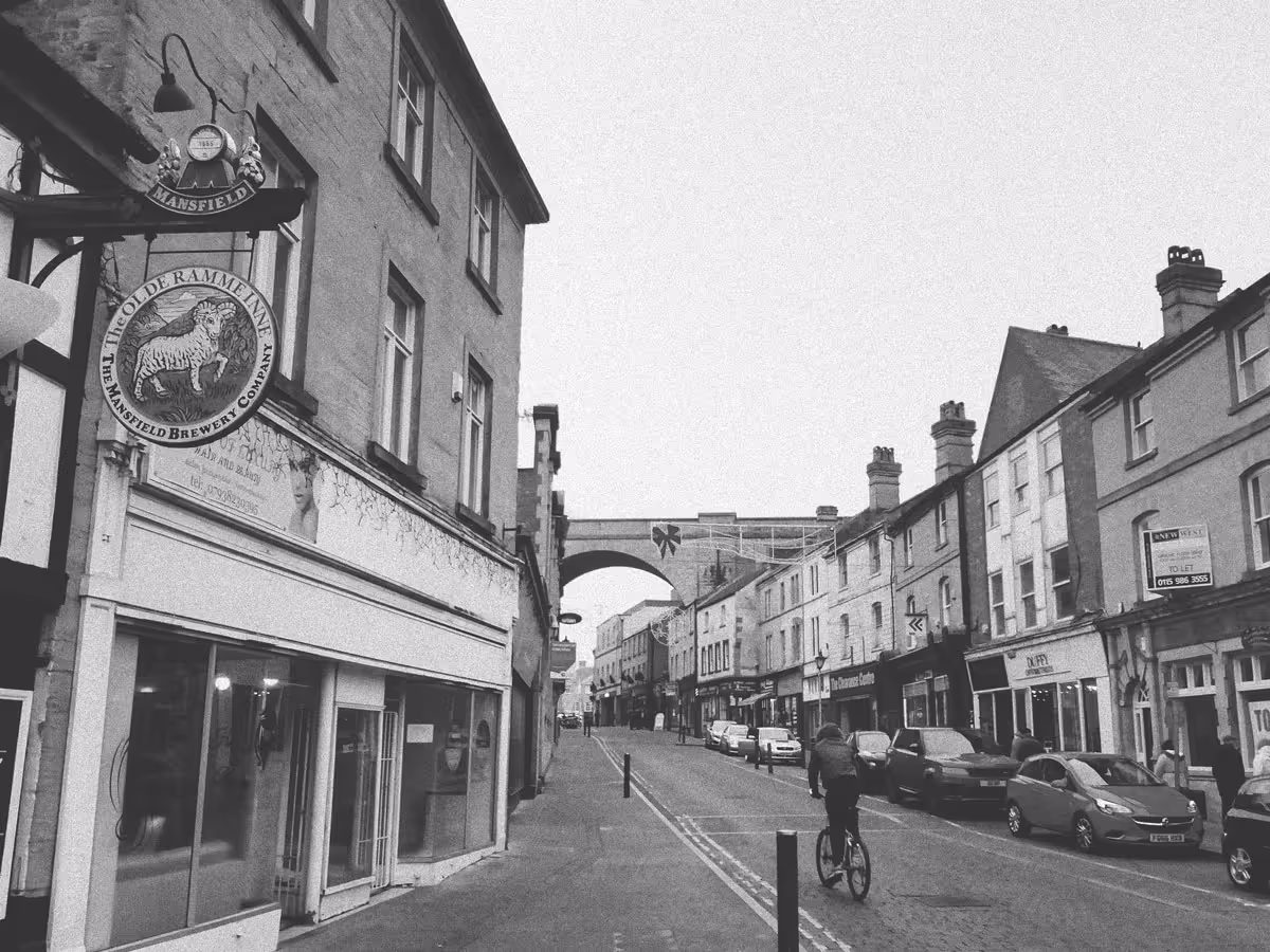 A black and white photo of Church Street in Mansfield, including pubs and shops.
