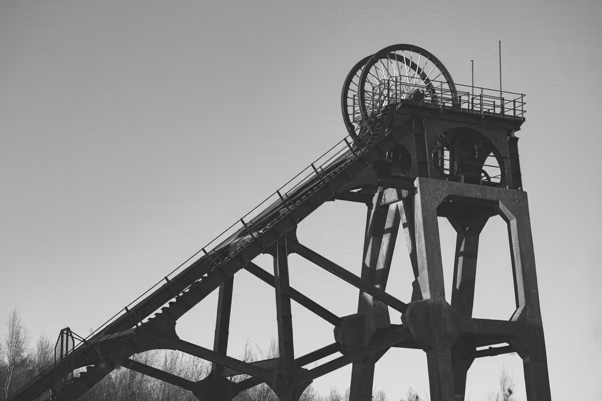 A black and white photo the industrial mining headframe structure which remains at the site of the closed Pleasely Pit in Mansfield, England.