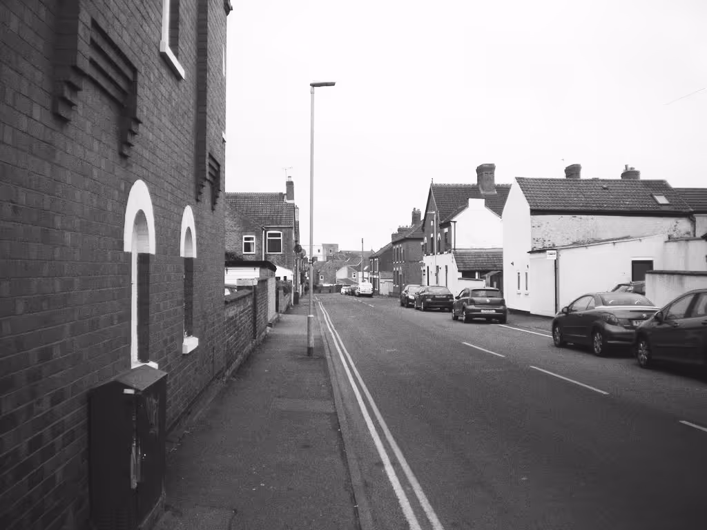 A black and white photo of a residential street in Coalville, England.