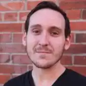 a man in front of a brick wall